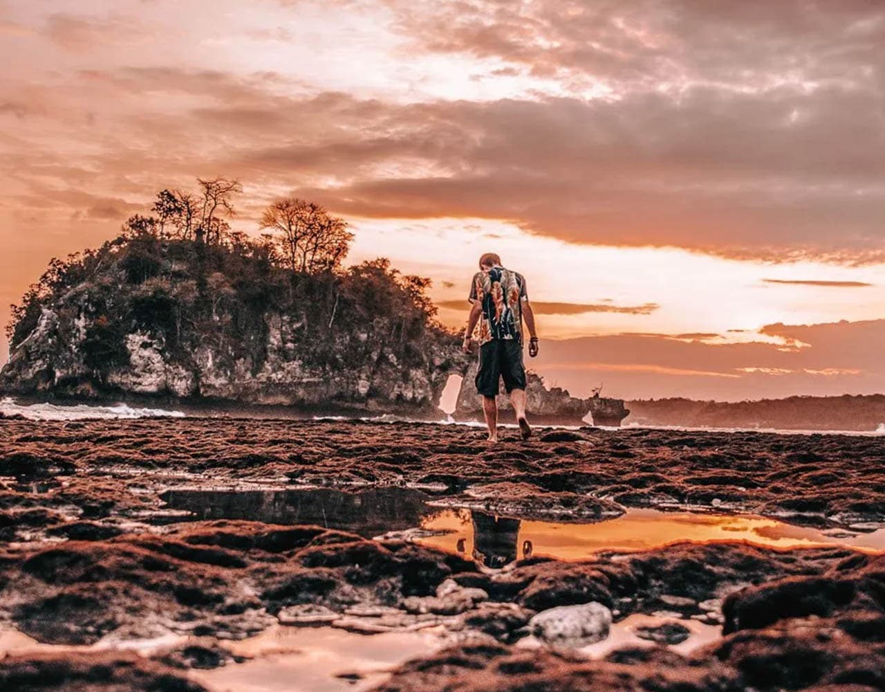 Nusa Penida Island_0006_Man-walking-on-Crystal-Bay-Beach-at-Sunset-deartravallure